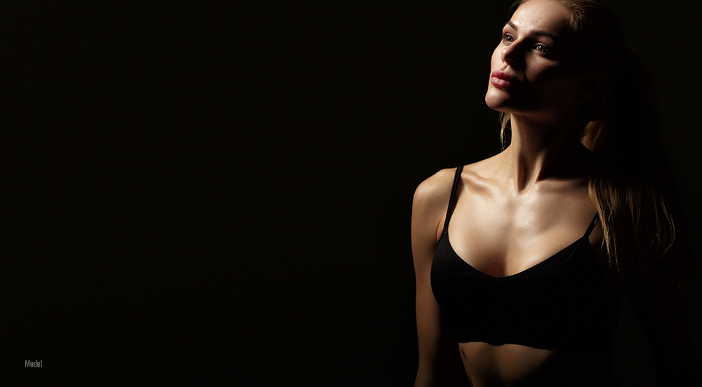 Female side profile in black background 